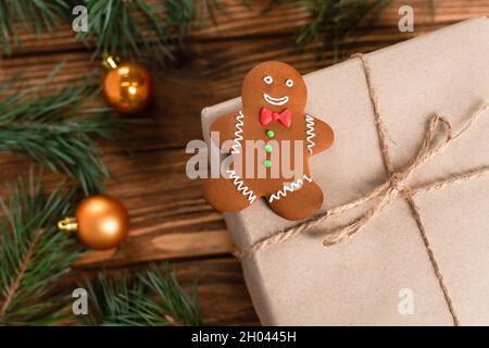 vue de dessus du biscuit au pain d'épice sur la boîte-cadeau près des branches de pin floues sur une surface en bois Banque D'Images