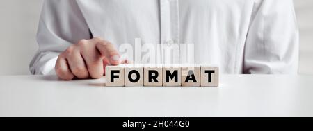 Homme d'affaires appuyant son doigt sur les cubes de bois avec le format de mot.Concept de formatage ou de réinitialisation. Banque D'Images