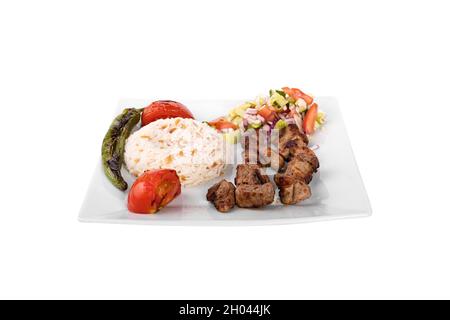 Viande d'agneau au kebab turc sur brochette. Avec légumes, riz dans une assiette de service en porcelaine sur fond blanc. Kusbasi, kusbasi kebap, sis kebap, kuzu sis Banque D'Images