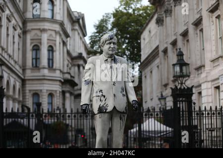 Londres, Angleterre, Royaume-Uni.11 octobre 2021.Greenpeace bloque Downing Street avec la statue de Boris Johnson recouverte de barils de pétrole et de pétrole.Le groupe de campagne veut arrêter les forages dans le champ pétrolier de Cambo, qui se trouve à environ 125 km au nord-ouest des îles Shetland, au large des côtes du Royaume-Uni.(Image de crédit : © Tayfun Salci/ZUMA Press Wire) Banque D'Images