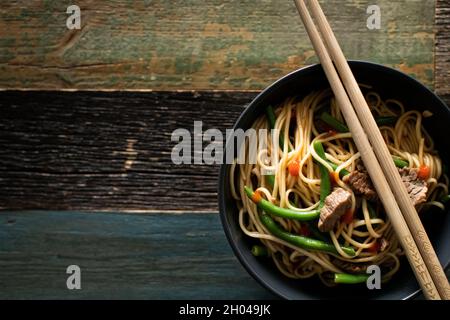 Ramen avec du bœuf et des nouilles aux œufs dans des bols sur fond de bois Banque D'Images