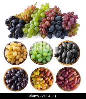 Raisins mixtes de différentes variétés.Raisins dans un bol en bois isolé sur fond blanc.Raisins bleus, jaunes, rouges et verts sur fond blanc.Vég Banque D'Images