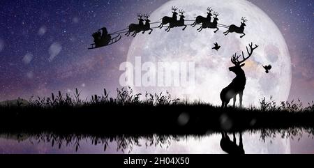 Silhouette de renne debout sur la falaise pour voir le Père Noël voler sur leur renne au-dessus de la pleine lune le soir de Noël. Banque D'Images