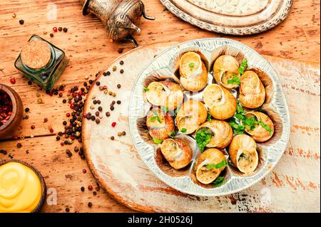 Escargots comestibles farcis au beurre vert, cuisine française. Banque D'Images