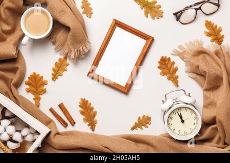 Concept d'automne.Des lunettes beige en cachemire encadrent une tasse à café avec des feuilles d'automne sur fond blanc.Espace de copie de la vue de dessus de la pose à plat Banque D'Images