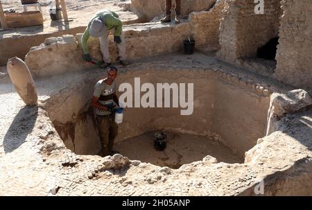 YAVNE, 11 octobre 2021 (Xinhua) -- des travailleurs opèrent sur le site d'excavation d'une ancienne usine de vin à Yavne, dans le centre d'Israël, le 11 octobre 2021.Les archéologues israéliens ont exposé une énorme usine de vin vieille de 1,500 ans, a déclaré lundi l'Autorité israélienne des Antiquités (IAA).L'immense et bien conçu domaine industriel de la période byzantine a été excavé au cours des deux dernières années dans la ville de Yavne, dans le centre d'Israël.(Photo de Gil Cohen Magen/Xinhua) Banque D'Images