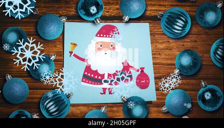 Image de neige tombant au-dessus du père noël et des boules de noël Banque D'Images