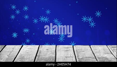 Image de flocons de neige tombant sur fond bleu et sol en bois Banque D'Images
