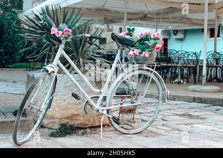 Magnifique vélo blanc garé à l'extérieur décoré de fleurs en Croatie Banque D'Images