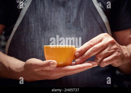 Le barista tient une tasse de café noir frais Banque D'Images