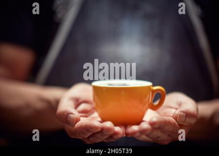 Le barista tient une tasse de café noir frais Banque D'Images