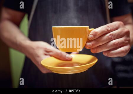 Le barista tient une tasse de café noir frais Banque D'Images