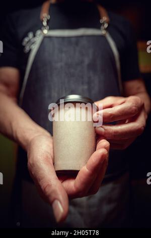 Le barista tient et sert deux tasses de café noir frais à emporter Banque D'Images