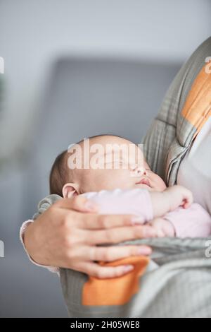 Gros plan de la mère tenant son bébé endormi sur les mains Banque D'Images