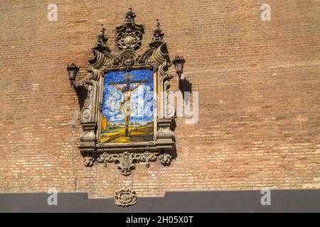 Azulejo montrant Jésus sur la croix sur un mur extérieur de l'Église de l'Annonciation (Iglesia de la Anunciacion) à Séville Espagne.L'église en R Banque D'Images