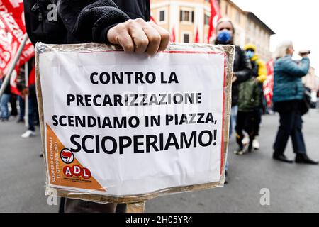 Bologne, Italie.11 octobre 2021.Les manifestants tiennent une bannière lors d'une grève générale organisée par les syndicats de la base (Cobas, Cub, USB) contre le gouvernement Draghi.Environ 3000 personnes, dont des étudiants et des travailleurs, ont assisté à la manifestation, parcourant les rues du quartier de Bolognina et du centre historique.Crédit: Massimiliano Donati/Alay Live News Banque D'Images