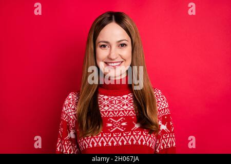 Portrait d'une jolie fille gaie portant un pull festal tricoté isolé sur fond rouge vif Banque D'Images