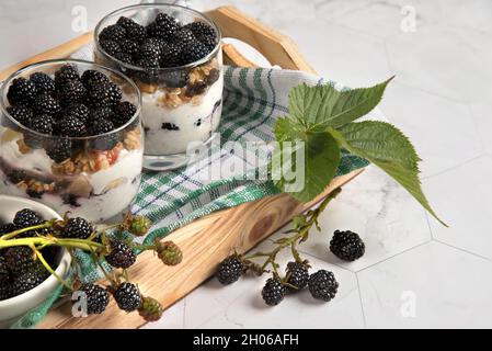 Deux verres de cheesecake blackberry sur un plateau en bois . Banque D'Images
