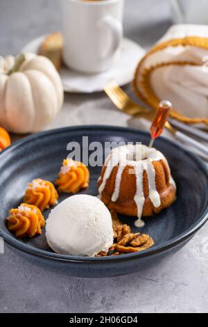 Petit gâteau de citrouille imbibé de rhum servi avec de la crème glacée Banque D'Images