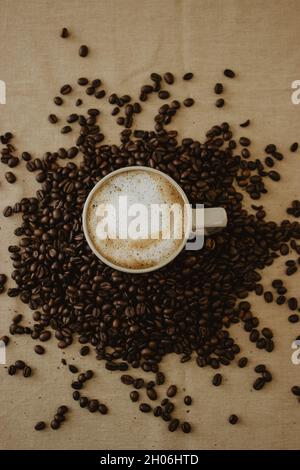 Tasse de café au fond des grains de café sur fond marron.Photographie de café STILL Life. Banque D'Images