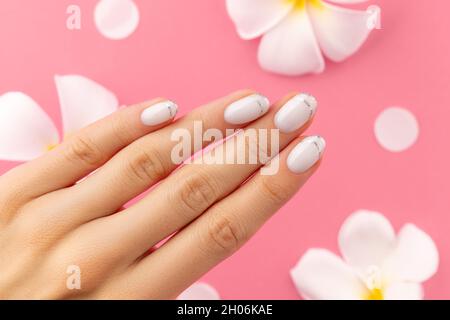 Mains des femmes avec manucure française blanche et tendance Banque D'Images