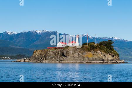 Adossée à des montagnes enneigées sur l'île de Vancouver, la station de lumière historique de Chrome Island est située au-dessus du détroit de Georgia, sur la côte ouest du Canada. Banque D'Images