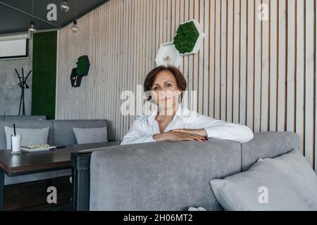 Femme d'affaires senior se reposer dans un café moderne. Banque D'Images