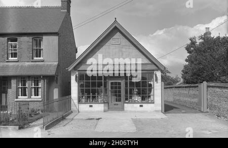 Années 1950, extérieur d'une coopérative locale, Wheatley, Oxford, Angleterre, Royaume-Uni,Construit en 1913 et détenu par la Oxford Co-operative and Industrial Society Ltd., le mouvement de la British Co-operative, connu sous le nom de la Co-Op, a commencé avec la Rochdale Society of Equitable Pioneers en 1844, une entreprise commerciale dirigée au profit de ses membres, qui recevraient un dividende des bénéfices.Environ 300 coopératives individuelles dans le nord de l'Angleterre deviennent la Co-operative Wholesale Society (CWS), une organisation fournissant à leurs membres leurs propres magasins avec des produits fabriqués dans les usines de leur société. Banque D'Images