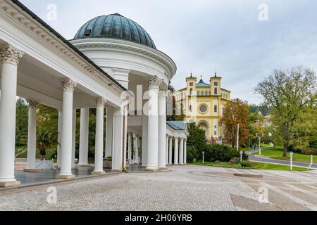 Colonnade (Kolonada) des sources Karolina et Rudolf (Karolinin - Rudolfuv pramen) et église catholique dans le centre de la ville thermale Marianske Lazne Banque D'Images