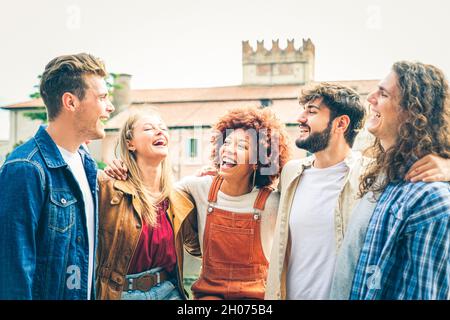 Groupe d'amis heureux rire ensemble - Groupe de mecs multiraciaux s'amuser dans la rue de la ville - Portrait de cinq étudiants de culture différente Banque D'Images