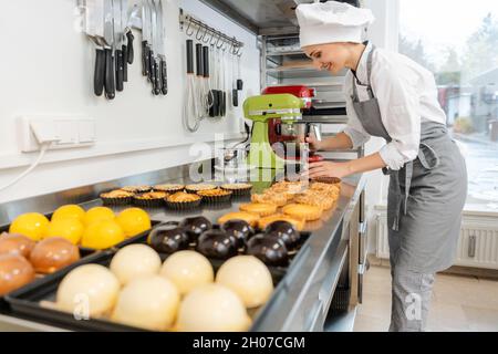 Confiseur travaillant sur un bon nombre de différents bonbons et desserts Banque D'Images