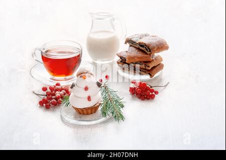 Bonhomme de neige en meringue douce avec décorations de Noël.Biscuits originaux avec guimauves et meringue sur la table de Noël avec thé et lait.C Banque D'Images