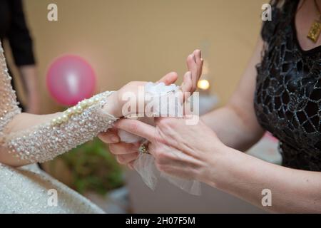 La main de la mariée est attachée à l'arc . La mariée met le mouchoir dans ses mains . Banque D'Images