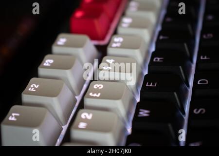 Clavier mécanique blanc rétroéclairé avec touches noires, blanches et rouges formant un angle Banque D'Images