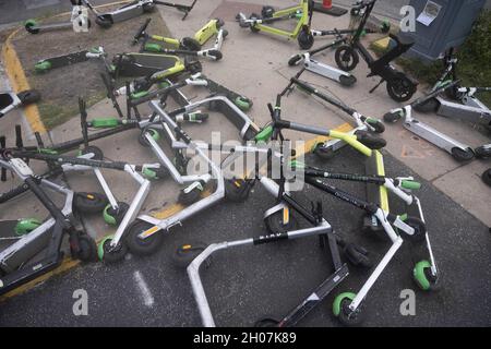 Austin, Texas USA, 10 octobre 2021 : les scooters électriques font une pile hasardeuse et un danger pour les piétons au coin de East First Street et de Red River après un week-end chargé dans les quartiers de divertissement de Red River et de Rainey Street dans le centre-ville d'Austin.©Bob Daemmrich Banque D'Images