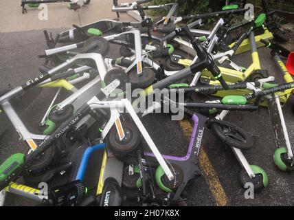 Austin, Texas USA, 10 octobre 2021 : les scooters électriques font une pile hasardeuse et un danger pour les piétons au coin de East First Street et de Red River après un week-end chargé dans les quartiers de divertissement de Red River et de Rainey Street dans le centre-ville d'Austin.©Bob Daemmrich Banque D'Images