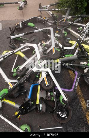 Austin, Texas USA, 10 octobre 2021 : les scooters électriques font une pile hasardeuse et un danger pour les piétons au coin de East First Street et de Red River après un week-end chargé dans les quartiers de divertissement de Red River et de Rainey Street dans le centre-ville d'Austin.©Bob Daemmrich Banque D'Images