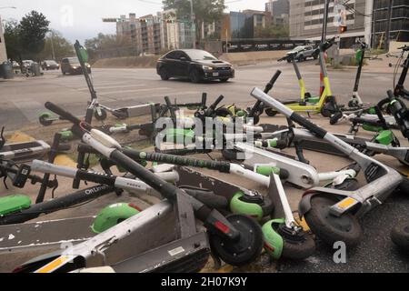 Austin, Texas USA, 10 octobre 2021 : les scooters électriques font une pile hasardeuse et un danger pour les piétons au coin de East First Street et de Red River après un week-end chargé dans les quartiers de divertissement de Red River et de Rainey Street dans le centre-ville d'Austin.©Bob Daemmrich Banque D'Images