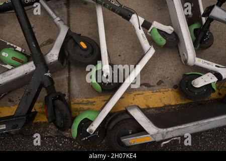 Austin, Texas USA, 10 octobre 2021 : les scooters électriques font une pile hasardeuse et un danger pour les piétons au coin de East First Street et de Red River après un week-end chargé dans les quartiers de divertissement de Red River et de Rainey Street dans le centre-ville d'Austin.©Bob Daemmrich Banque D'Images