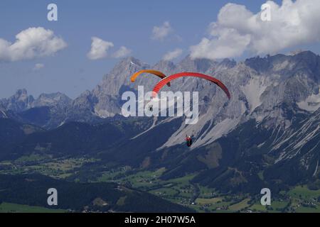Deux amis parapente dans les Alpes de la région de Dachstein en Autriche Banque D'Images