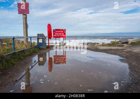 Danger, attention au panneau de chute de roches au village côtier de Skinningrove, Cleveland, Angleterre, Royaume-Uni Banque D'Images