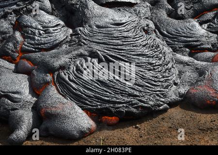 Coulée de lave de Pahoehoe à Faggadalsfjall, en Islande.La croûte de lave est grise et noire, la lave fondue est rouge et orange.Formation d'un nouveau lobe de lave d'opie. Banque D'Images