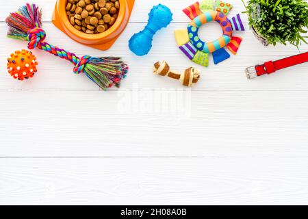 Sécher la nourriture pour chiens dans un bol avec des jouets et des friandises, vue du dessus Banque D'Images