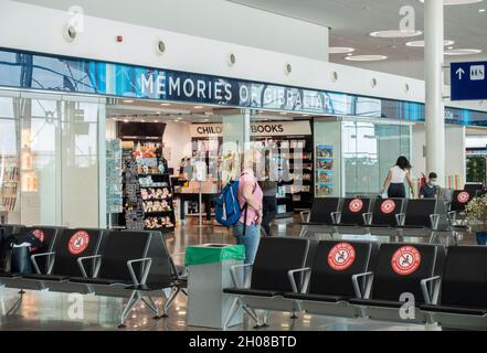 Partie du salon de passagers de l'aéroport de Gibraltar avec la boutique de souvenirs Memories of Gibraltar.Certains passagers portant un masque se trouvent dans la zone. Banque D'Images