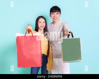 Heureux couple montrant des sacs de shopping.isolé sur fond bleu. Banque D'Images