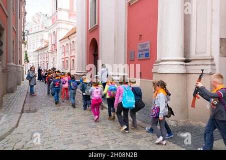 POZNAN, POLOGNE - 03 février 2016 : un groupe d'enfants d'une excursion scolaire passant devant une église dans le centre-ville Banque D'Images