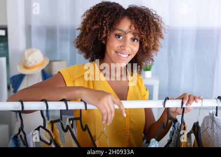 femme taille basse derrière le rail de vêtements Banque D'Images