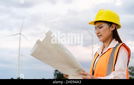 une jeune femme ingénieur analyse un schéma de la ferme éolienne Banque D'Images