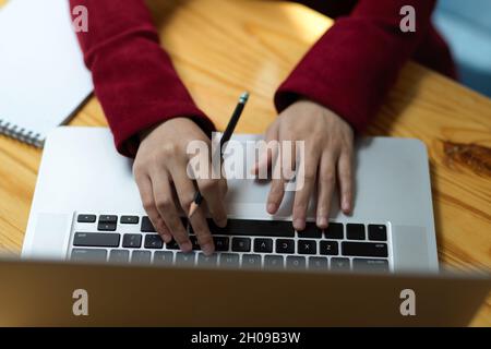 Gros plan, vue de dessus des mains de femme d'affaires dactylographiant sur le clavier d'ordinateur portable, woking sur ordinateur portable. Banque D'Images