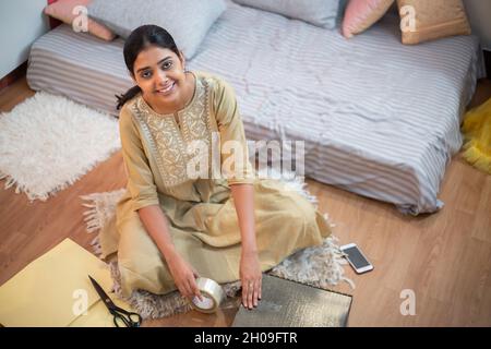 Portrait de la jeune femme d'affaires indienne paquet de nouveaux vêtements ou robes pour la vente de magasin Web, petite ligne de vêtements propriétaire de démarrage en ligne, préparer des produits pour Banque D'Images